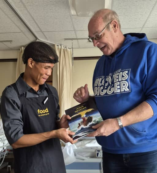 Leo Baan handing a Jesus Messiah graphic novel to a hospital staff member in Cape Town